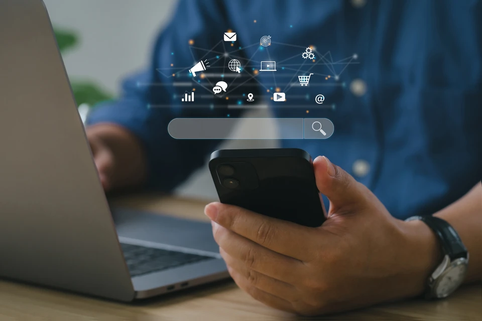 Espace de travail numérique moderne avec ordinateur central affichant interface web bleue